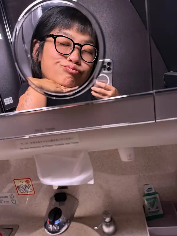 Jackie pulling a face into a round bathroom mirror